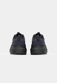 Zapatillas oscuras moradas con una parte superior texturizada, suela negra acolchada y tirador en el talón. Presentan una forma redondeada y un diseño en capas.