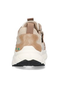 Baskets avec une semelle blanche épaisse, une tige en daim beige, des accents brillants en bronze et une boucle à l'arrière pour un enfilage facile. Semelle avec des crampons noirs.