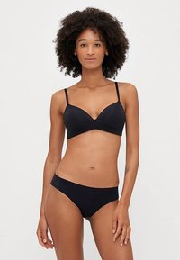 Must detailirohuga rinnahoidja ja bikiinide komplekt. Pehme materjal, kraaditud disain, reguleeritavad rihmad ning madala vöökohaga sobivus. Sile tekstuur. Ilma mustrite või lisavidinateta.