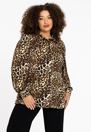 Blouse à imprimé léopard avec un col, des manches longues bouffantes et une coupe décontractée. Le tissu est doux avec une finition brillante.
