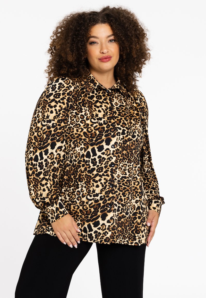 Blouse met luipaardprint, voorzien van een kraaglijn, lange pofmouwen en een relaxed fit. De stof is zacht met een glanzende afwerking.