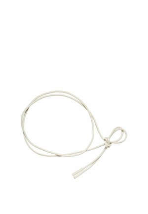 Lacet rond blanc pour chaussures, noué lâchement avec un simple nœud et embouts en plastique aux deux extrémités sur un fond uni.