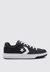 Adidași negri de tip low-top, fabricați din piele sintetică, cu un logo alb în formă de stea, șireturi albe și o talpă din cauciuc cu textură antiderapantă.