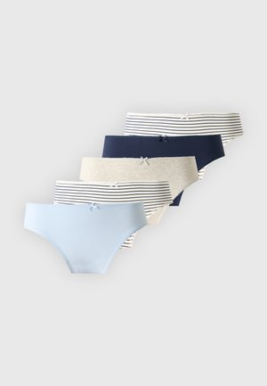 Femme aux longs cheveux bruns, debout pieds nus, portant un soutien-gorge bleu marine et une culotte assortie sur un fond clair uni.