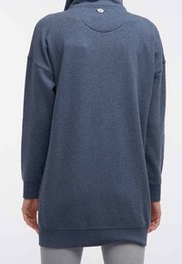 Felpa blu scuro con collo alto, maniche lunghe e vestibilità comoda. Caratteristica distintiva: un piccolo logo sul retro.