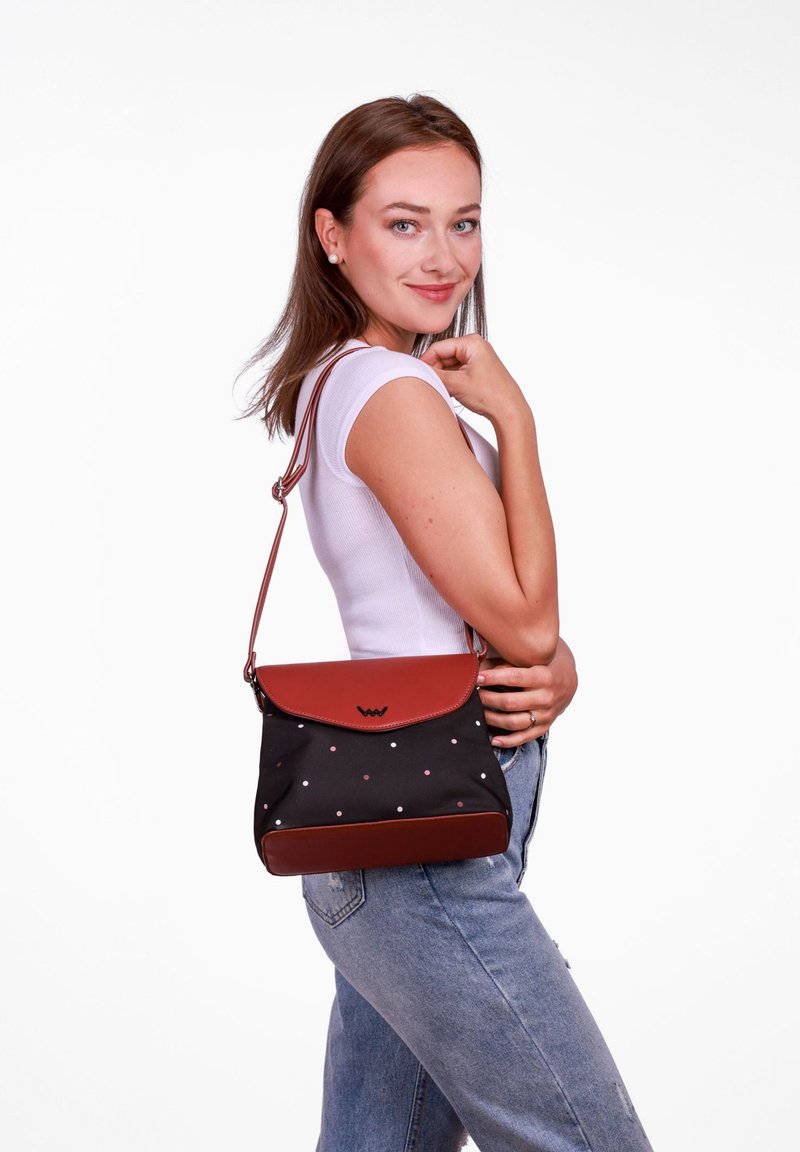 Černá a hnědá kabelka s klopou, texturovaná látka a proužkovaný vzor. Nastavitelný popruh pro nošení na rameni nebo přes tělo.