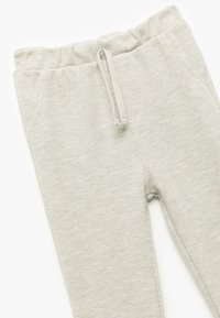Lys grå sweatpants lavet af tekstureret stof, med elastisk talje, snøre og sidelommer.