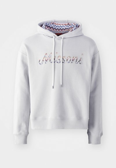 Svetlo siva kapuca s kenguruvim žepom, koja ima obojeni zigzag uzorak unutar kapuljače. "Missoni" je izvezen multicolor koncem.