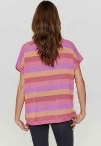 Blusa de manga corta con rayas horizontales en morado, rosa y dorado. La tela tiene una textura brillosa, un corte holgado y un escote redondeado.