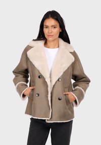Brown suede jacket with a white faux fur collar and lining. Features double-breasted buttons and side pockets. Textured finish.