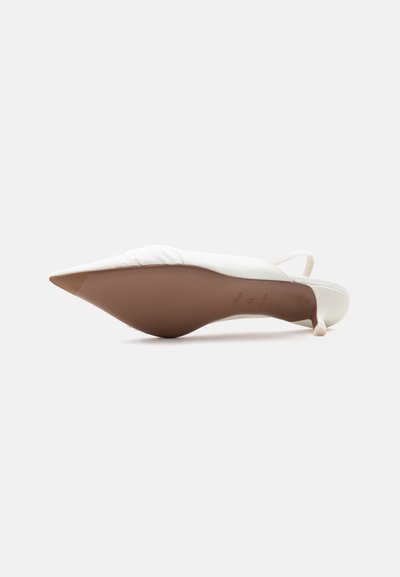 Λευκό γυναικείο παπούτσι slingback με μυτερή μύτη, εμφανιζόμενο από την σόλα με καφέ πάτο και λεπτό τακούνι σε λευκό φόντο.