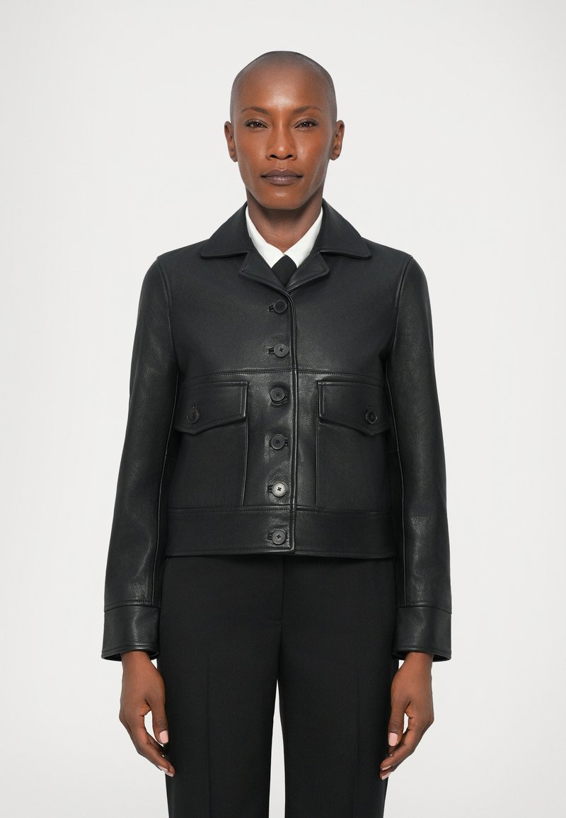 Zwarte leren cropped jack met een omgeslagen kraag, knoopsluiting en twee borstzakken. Glad textuur en op maat gemaakte pasvorm.