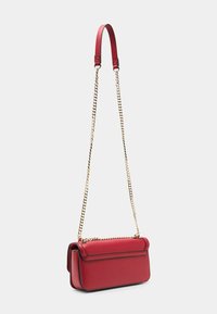 Červená kožená crossbody taška se strukturovaným tvarem, horní klopou a zlatým řetízkem. Disponuje hladkým povrchem a kontrastním prošíváním.