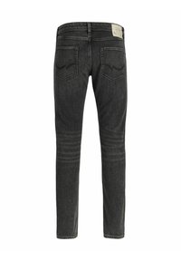 Jeans de mezclilla de color gris oscuro con un diseño ajustado, cinco bolsillos y costuras visibles. En la parte trasera presenta dos bolsillos de forma estándar.