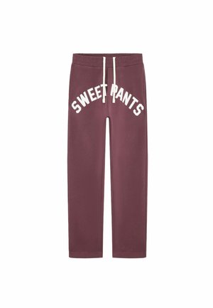 Un pantalon de survêtement bordeaux avec un imprimé blanc en courbe "SWEET PANTS" sur le devant, une taille élastique et un cordon de serrage. Tissu doux avec une texture lisse.