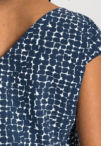 Abito blu navy con un motivo astratto bianco, caratterizzato da un ampio scollo e maniche corte, realizzato in un tessuto liscio.