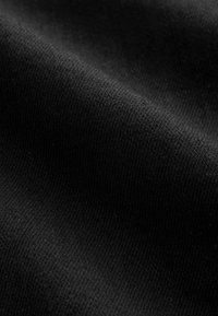 Tessuto nero con una texture liscia, caratterizzato da sottili motivi intrecciati. La superficie riflette leggermente la luce, mostrando profondità e morbidezza.