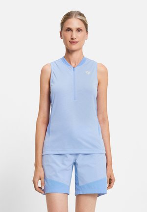 Woman standing, wearing a sleeveless light blue zip-up top and matching light blue shorts against a plain white background.