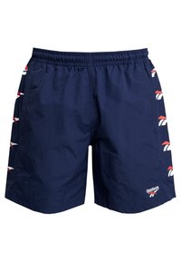 Námořnické modré šortky s elastickým pasem, bočními kapsami a logem Reebok. Na bocích se nacházejí červené a bílé akcenty loga. Lehce materiál.