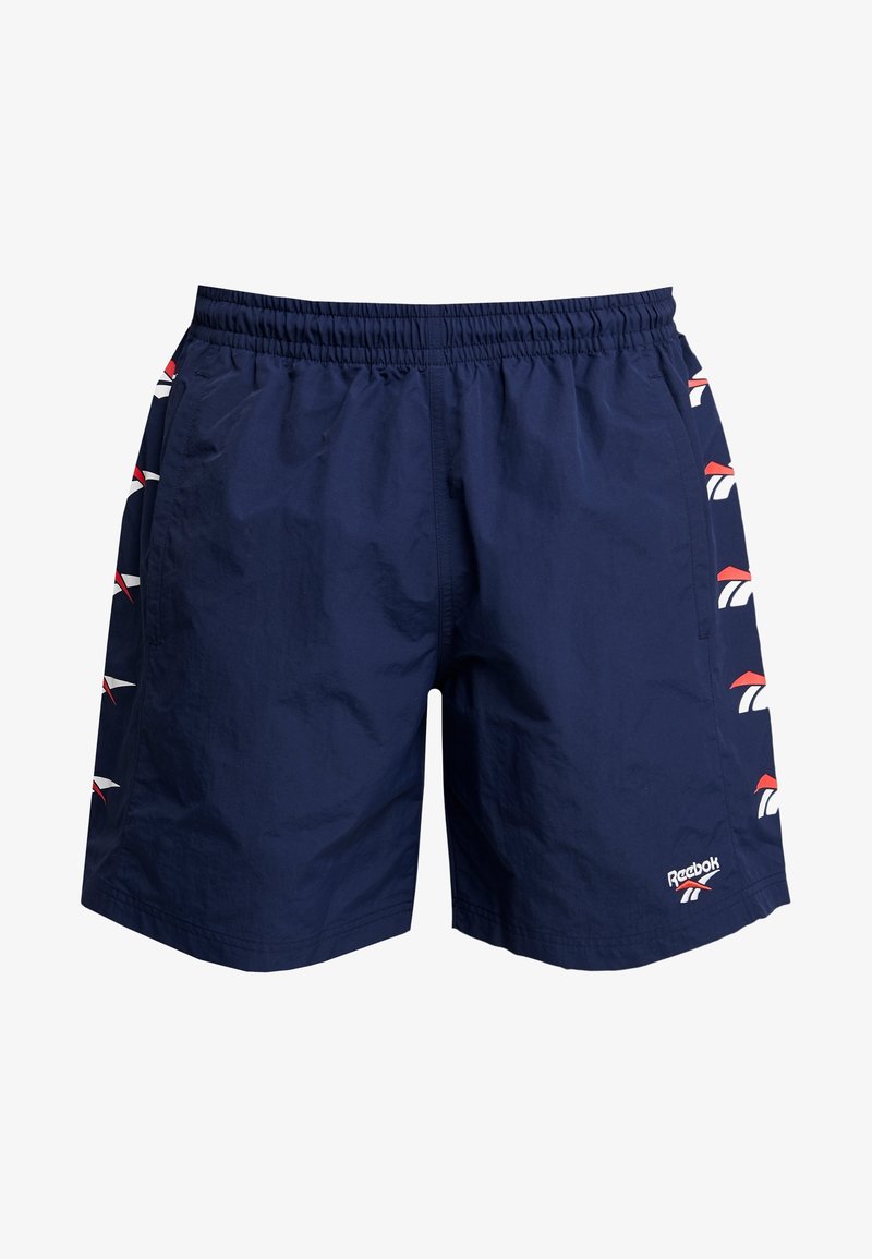 Námořnické modré šortky s elastickým pasem, bočními kapsami a logem Reebok. Na bocích se nacházejí červené a bílé akcenty loga. Lehce materiál.