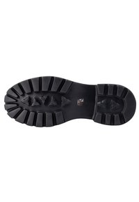 Semelle en caoutchouc présentant un design robuste et texturé avec des rainures profondes et des motifs triangulaires en relief pour une meilleure adhérence ; couleur noire prédominante.