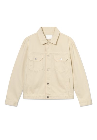 Smėlio spalvos džinsinė striukė su sagomis, dviem priekinėmis kišenėmis su atvartais ir ilgomis rankovėmis, išdėstyta ant baltos fono.
