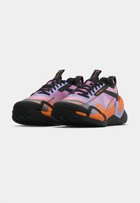 Μωβ και μαύρα αθλητικά παπούτσια με πορτοκαλί λεπτομέρειες. Διαθέτουν υφή στη σόλα και επάνω μέρος από δίχτυ με κορδόνια, καθώς και θηλιά για εύκολη χρήση.