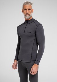 Mørkegrå langærmet pullover med halvdelt lynlås i halsen, med stikninger, en tætsiddende design og et logo på brystet.