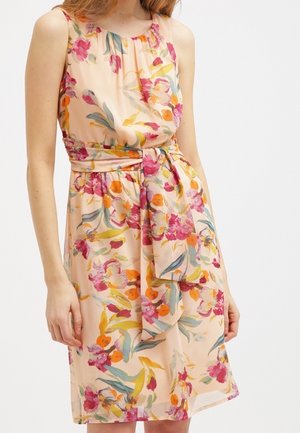 Robe florale en tissu pêche doux, dotée d'un design sans manches, d'un col froncé et d'une ceinture à nouer, ornée de motifs roses, oranges et verts.