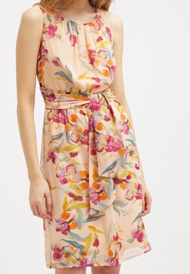 Robe florale en tissu pêche doux, dotée d'un design sans manches, d'un col froncé et d'une ceinture à nouer, ornée de motifs roses, oranges et verts.