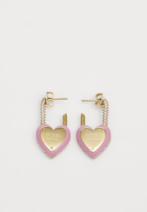 Guld- og pinkfarvede hjerteformede øreringe i hoop-design med rhinsten og "GUESS EST. 1981" indgraveret på forsiden.