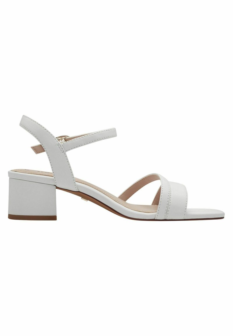 Sandale en cuir blanc avec un talon carré, dotée de deux larges brides et d'une sangle de cheville réglable. Texture lisse et design minimaliste.