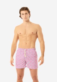 Costumi da bagno con un motivo geometrico colorato in rosa, blu e bianco. Realizzati in tessuto leggero, dotati di una cintura elastica e cordino.