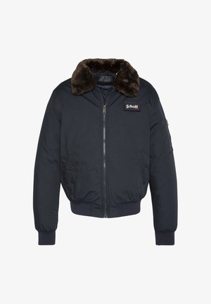 Marineblauwe bomberjack met een bruine nepbontkraag, een ritssluiting aan de voorkant, geribbelde boorden en een zak op de linkerarm. "Schott" logo patch aanwezig.