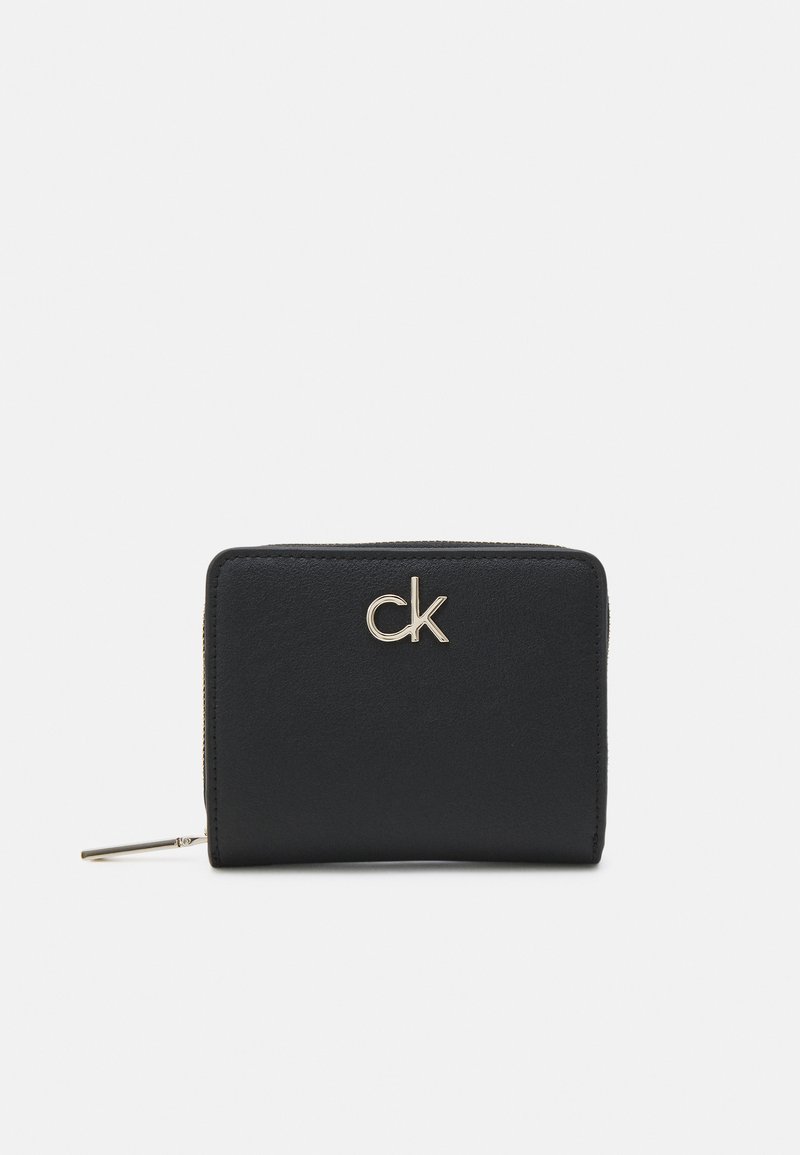 Black wallet made of smooth leather, featuring a gold-toned "ck" logo on the front, zip closure, and rectangular shape.