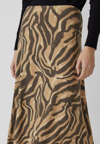 Lange Rock mit einem Tierdruck in verschiedenen Brauntönen und Beige. Der Stoff wirkt texturiert mit unterschiedlichen Mustern und Linien.