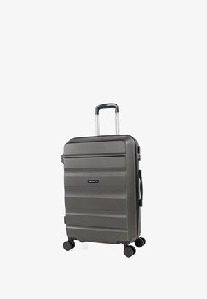 Maleta rígida gris con asa telescópica, cuatro ruedas giratorias, asa lateral y logotipo de la marca ITACA en el panel frontal.