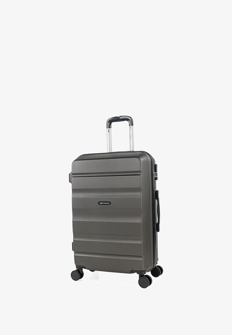 Maleta rígida gris con asa telescópica, cuatro ruedas giratorias, asa lateral y logotipo de la marca ITACA en el panel frontal.