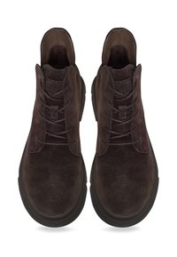 Paita tummanruskeita mokkanahkakenkiä, joissa on paksut mustat pohjat, katsottuna ylhäätapäin valkoista taustaa vasten.