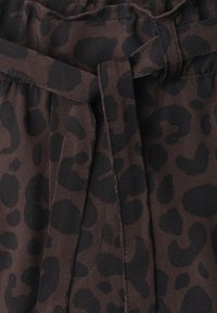Dark brown fabric with black leopard print and a stitched waistband tie knot.