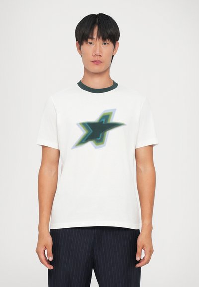 Camiseta blanca de algodón con un gráfico abstracto de estrella en verde y azul en el frente, con un cuello acanalado verde. Mangas de corte recto.