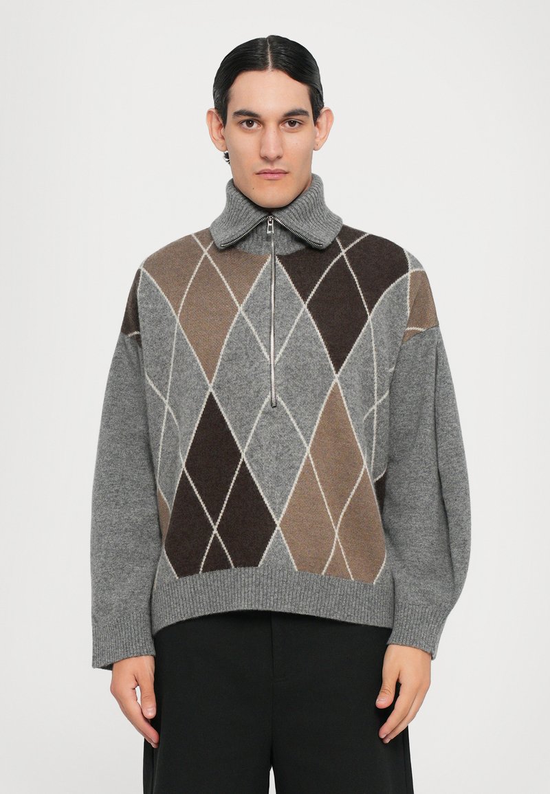 Suéter gris de rombos con patrones geométricos en marrón y beige, con cuello acanalado y cierre de cremallera en la parte delantera. Tejido suave de mezcla de lana. Diseño corto.