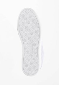 Bílá podrážka tenisky s texturovaným gumovým designem, opakovaným vzorem loga, hladkými okraji a obdélníkovou značkovou nálepkou.