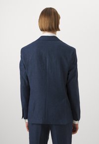 Σκούρο μπλε λινό σακάκι με έναν αεραγωγό, με αυλακωτούς πέτους και δύο πίσω τσέπες. Διαθέτει υφή υφάσματος και κουμπωτά μανίκια.