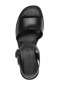 Svart lädersandal med en bred rem och justerbar spänne. Texturerad fotbädd och böjd sula för stöd. Varumärkeslogotyp synlig på innersulan.