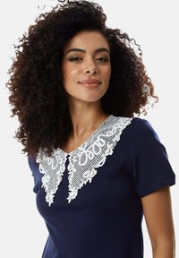 Navy dress featuring a white lace collar with intricate patterns. Short sleeves, smooth texture, and a fitted silhouette.