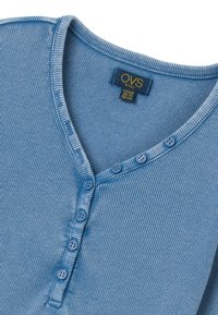 Blau gestreiftes Baumwollhemd mit V-Ausschnitt, ausgestattet mit einer Knopfleiste und kleinen runden Knöpfen. Das Etikett trägt die Aufschrift "OVS kids" mit Größenangaben.