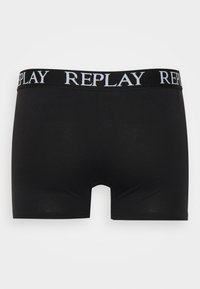 Svart boxer shorts laget av glatt stoff, med en bred elastisk midjebånd med ordet "REPLAY" i hvit skrift.