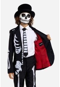 Black skeleton-themed suit featuring white bone prints, red lining, and a matching striped tie. Worn with a black top hat and face paint.