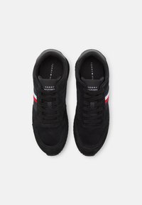 Sneakers athletic neri con tomaia in rete e camoscio, dettagli testurizzati, strisce bianche e rosse a contrasto e colletto imbottito.